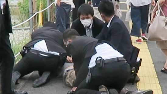 Four armed police officers pin down Tetsuya Yamagami after he shot former Japan Prime Minister Shinzo Abe in Nara on Friday.