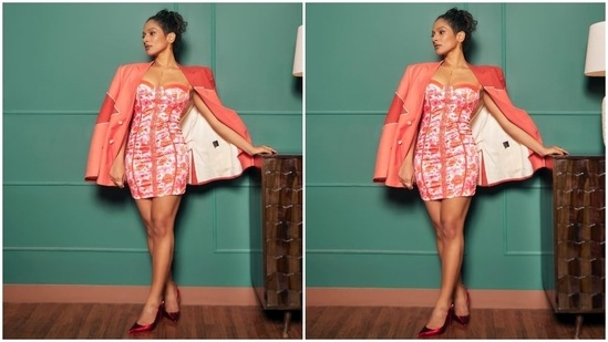 Masaba wore a floral corset dress featuring contrast orange lining, a multi-coloured floral pattern on a white backdrop, corseted silhouette hugging her curves aesthetically, a mini hem length, and a plunging sweetheart neckline. An oversized peach jacket with padded shoulders, long sleeves and an open front, layered on the shoulders, completed the outfit.(Instagram)