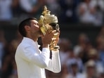 Serbia's Novak Djokovic celebrates with the trophy after winning the men's singles final against Australia's Nick Kyrgios