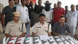 The arrested arms suppliers and the weapons seized from them in the Palwal police custody on Sunday. (Twitter)