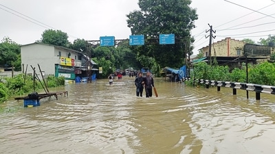 People wade through a waterlogged street after heavy rainfall, in Navsari in Gujarat on Sunday. (ANI) People wade through a waterlogged street after heavy rainfall, in Navsari in Gujarat on Sunday. (ANI)