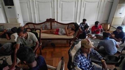 Protesters stay and play cards in prime minister's official residence a day after it was stormed in Colombo, Sri Lanka, Sunday, July 10, 2022. (AP) Protesters stay and play cards in prime minister's official residence a day after it was stormed in Colombo, Sri Lanka, Sunday, July 10, 2022. (AP)