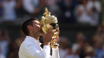 Serbia's Novak Djokovic celebrates with the trophy after winning the men's singles final against Australia's Nick Kyrgios (REUTERS)