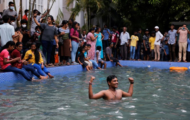 A man stands in the swimming pool as people visit the President's house in Colombo, Sri Lanka, on Sunday. (REUTERS)