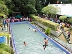 Protesters swim as onlookers wait at a swimming pool in the president's official residence.(AP)