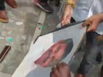 Supporters of O Paneerselvam slap slippers on Edappadi Palaniswamy's photo in protest over his new role.