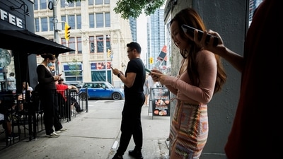 People use electronics outside a coffee shop in Toronto amid a nationwide Rogers outage, affecting many of the telecommunication company's services. (AP) People use electronics outside a coffee shop in Toronto amid a nationwide Rogers outage, affecting many of the telecommunication company's services. (AP)