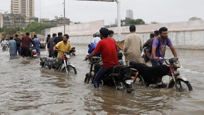Residents commute through a flooded road during the monsoon season in Karachi, Pakistan. (REUTERS)