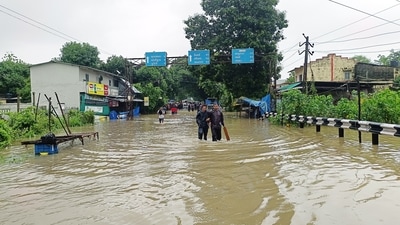 People wade through a waterlogged street after heavy rainfall, in Navsari in Gujarat on Sunday. (ANI) People wade through a waterlogged street after heavy rainfall, in Navsari in Gujarat on Sunday. (ANI)