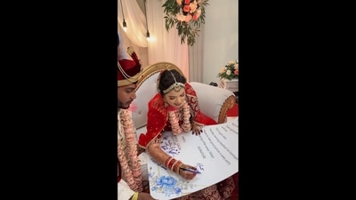 The image that shows a bride and a groom signing a wedding contract has been taken from the viral video posted on Instagram. (Instagram/@wedlock_photography_assam) The image that shows a bride and a groom signing a wedding contract has been taken from the viral video posted on Instagram. (Instagram/@wedlock_photography_assam)