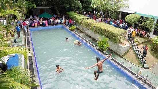 Protesters swim as onlookers wait at a swimming pool in the president's official residence.(AP)
