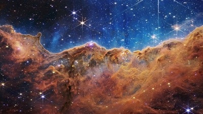 The ‘Cosmic Cliffs' of the Carina Nebula is seen in an image divided horizontally by an undulating line between a cloudscape forming a nebula along the bottom portion and a comparatively clear upper portion. (REUTERS)