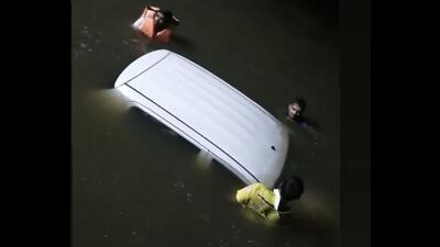 Locals pulling out the cab that drowned in a lake in Thane. The cab driver drove into the lake as he was new to the area and the lake was overflowing into the road. He was rescued by the locals. (HT PHOTO) Locals pulling out the cab that drowned in a lake in Thane. The cab driver drove into the lake as he was new to the area and the lake was overflowing into the road. He was rescued by the locals. (HT PHOTO)