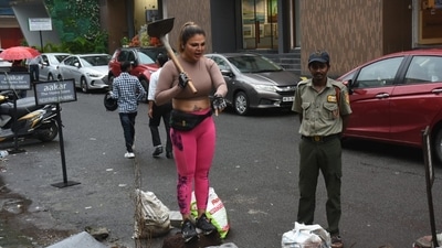 Rakhi Sawant was seen picking up the garbage outside her gym on Monday. She found garbage on her regular visit to the gym and started picking it up all by herself. She also turned down claims of contesting elections and said that she doesn't trust any political party, (Varinder Chawla) 