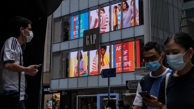 Pedestrians wearing protective masks walk past a Gap Inc. store in the Central district of Hong Kong. (Bloomberg) Pedestrians wearing protective masks walk past a Gap Inc. store in the Central district of Hong Kong. (Bloomberg)
