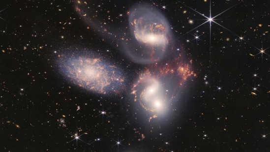 This image shows Stephan's Quintet, a visual grouping of five galaxies captured by the Webb Telescope's Near-Infrared Camera (NIRCam) and Mid-Infrared Instrument (MIRI). (AP)