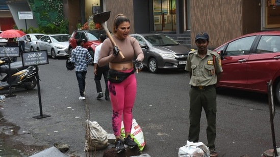 Rakhi Sawant was seen picking up the garbage outside her gym on Monday. She found garbage on her regular visit to the gym and started picking it up all by herself. She also turned down claims of contesting elections and said that she doesn't trust any political party, (Varinder Chawla)