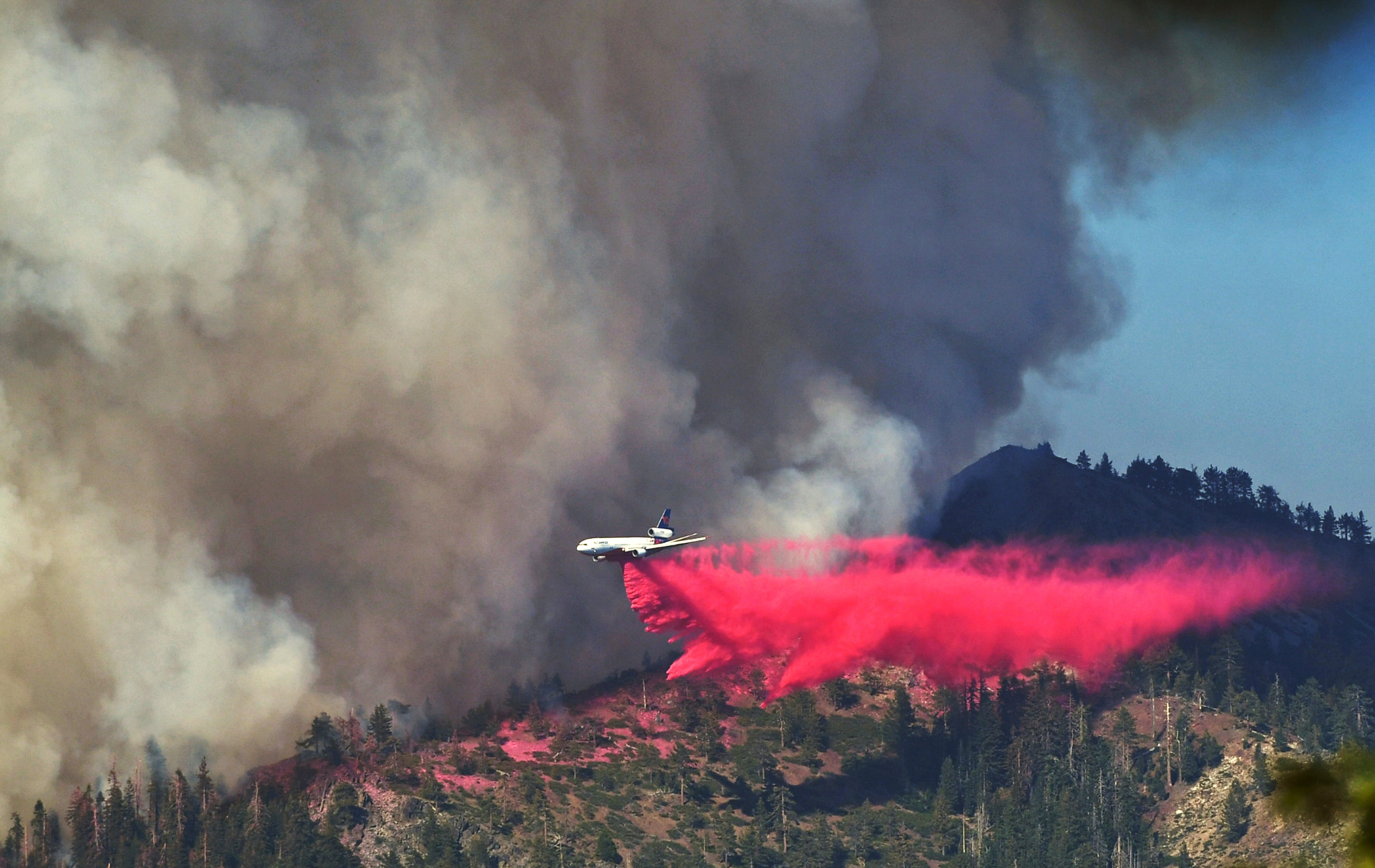A plane drops fire retardant on the Washburn Fire as it burns near the Mariposa Grove of giant sequoias and the south entrance of Yosemite National Park. (AP) A plane drops fire retardant on the Washburn Fire as it burns near the Mariposa Grove of giant sequoias and the south entrance of Yosemite National Park. (AP)