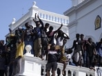 Sri Lankan protesters, some holding national flags, after storming the Prime Minister Ranil Wickremesinghe's office, demanding he resign after president Gotabaya Rajapaksa fled the country amid economic crisis in Colombo, Sri Lanka. (AP)