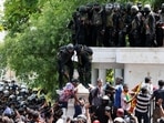 Security personnel push a man away as demonstrators gather outside the office of Sri Lanka's Prime Minister Ranil Wickremesinghe, amid the country's economic crisis, in Colombo.