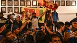 Manifestantes gritam slogans e agitam bandeiras do Sri Lanka dentro do prédio de escritórios do primeiro-ministro do Sri Lanka durante um protesto antigoverno em Colombo.