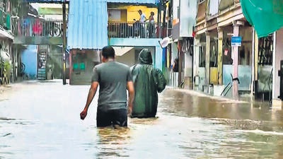 Navsari, July 13 (ANI): People walk on the waterlogged street following heavy rainfall, at Jalalpore, in Navsari on Wednesday. (ANI Photo) (ANI) Navsari, July 13 (ANI): People walk on the waterlogged street following heavy rainfall, at Jalalpore, in Navsari on Wednesday. (ANI Photo) (ANI)