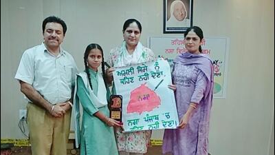 A student being awarded a trophy for her poster on drug abuse by the Khanna SDM Manjeet Kaur in Ludhiana. (HT PHOTO)