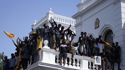Sri Lankan protesters, some holding national flags, after storming the Prime Minister Ranil Wickremesinghe's office, demanding he resign after president Gotabaya Rajapaksa fled the country amid economic crisis in Colombo, Sri Lanka. (AP) Sri Lankan protesters, some holding national flags, after storming the Prime Minister Ranil Wickremesinghe's office, demanding he resign after president Gotabaya Rajapaksa fled the country amid economic crisis in Colombo, Sri Lanka. (AP)