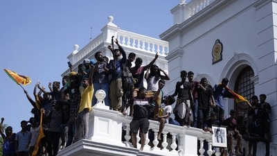 Sri Lankan protesters, some holding national flags, after storming the Prime Minister Ranil Wickremesinghe's office, demanding he resign after president Gotabaya Rajapaksa fled the country amid economic crisis in Colombo, Sri Lanka. (AP) Sri Lankan protesters, some holding national flags, after storming the Prime Minister Ranil Wickremesinghe's office, demanding he resign after president Gotabaya Rajapaksa fled the country amid economic crisis in Colombo, Sri Lanka. (AP)