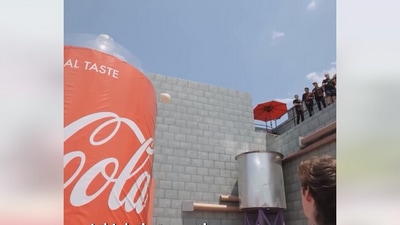 The image, taken from the viral Facebook video, shows a contestant trying to throw a huge mentos into a massive soda bottle as a part of Willy Wonka chocolate factory themed challenge. (YouTube/@MrBeast)