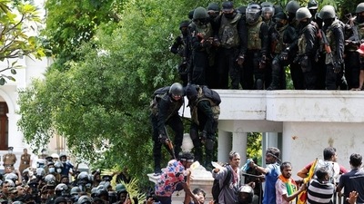 Security personnel push a man away as demonstrators gather outside the office of Sri Lanka's Prime Minister Ranil Wickremesinghe, amid the country's economic crisis, in Colombo. (REUTERS)