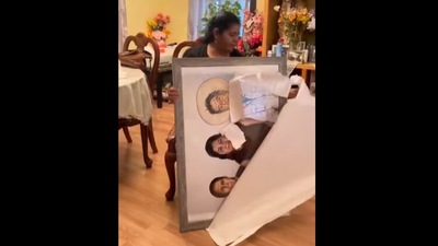 The woman's mother with the painting of her with her parents. (Instagram/@goodnewscorrespondent) The woman's mother with the painting of her with her parents. (Instagram/@goodnewscorrespondent)