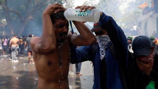 A demonstrator pours water on a man during a protest outside the office of Sri Lanka's Prime Minister Ranil Wickremesinghe.(Reuters)