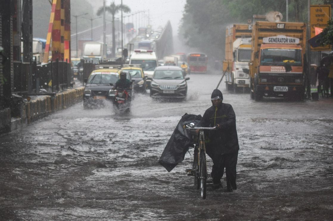 Vehicles drive through waterlogged street at Gandhi Market, Sion in Mumbai, India, on Wednesday, July 13, 2022. (Photo by Pratik Chorge/Hindustan Times)