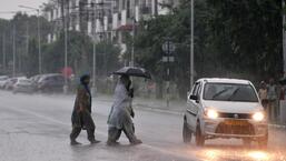 Women caught in the downpour near Sector 51 in Chandigarh on Thursday. (Ravi Kumar/HT)