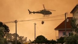 A fire fighting helicopter works to contain a wildfire in Leiria, Portugal. 