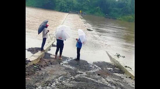 The bridge connecting Walkas village to Khadavli is submerged under Bhatsa river. Khadavli villages in Kalyan have lost connectivity with the city due to heavy rains. (PRAMOD TAMBE/HT PHOTO)