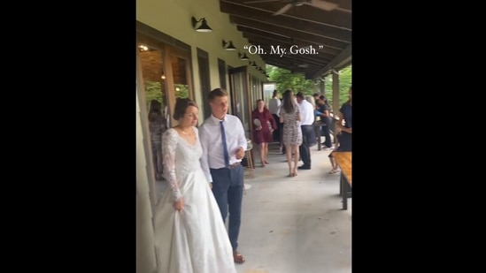 The image, taken from the viral video on Instagram, shows the bride looking at the live painting of her wedding ceremony. (Instagram/@withloveco.art)