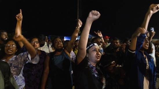 Demonstrators cheer after hearing news that Gotabaya Rajapaksa, Sri Lanka's president, emailed a letter of resignation, at a protest site close to the president's office in Colombo, Sri Lanka, on Thursday, July 14, 2022. (Buddhika Weerasinghe/Bloomberg)