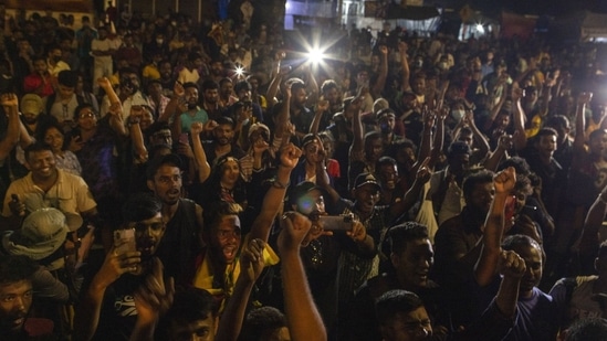 Demonstrators cheer after hearing news that Gotabaya Rajapaksa, Sri Lanka's President, emailed a letter of resignation, at a protest site close to the president's office in Colombo, Sri Lanka, on Thursday, July 14, 2022. (Buddhika Weerasinghe/Bloomberg)