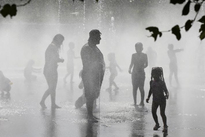 Pessoas se refrescam em uma fonte no Madrid Rio Park durante a segunda onda de calor do ano em Madri, Espanha. (Reuters)