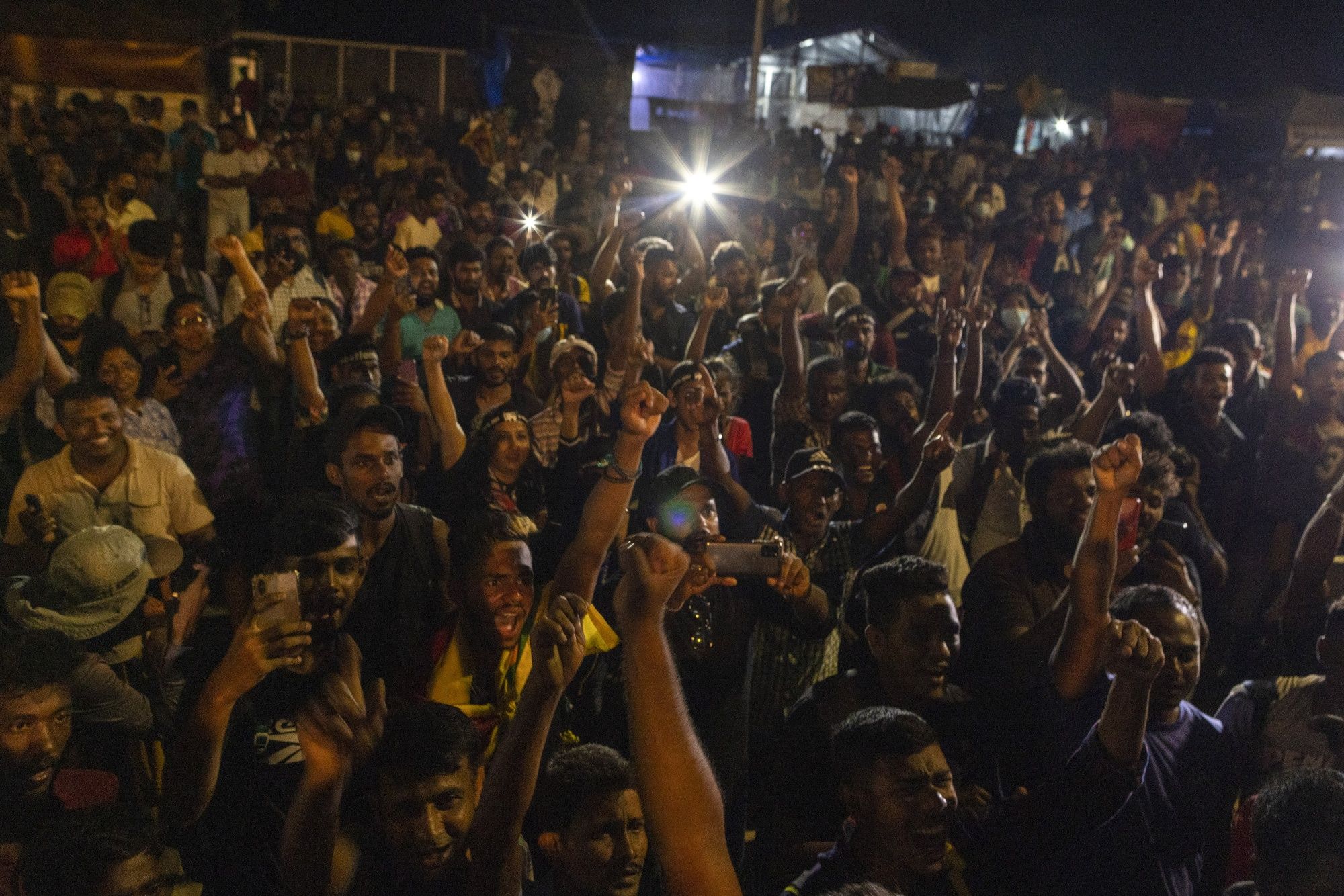 Demonstrators cheer after hearing news that Gotabaya Rajapaksa, Sri Lanka's President, emailed a letter of resignation, at a protest site close to the president's office in Colombo, Sri Lanka, on Thursday, July 14, 2022. (Buddhika Weerasinghe/Bloomberg)