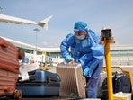 A worker, wearing a protective suit following the coronavirus disease (COVID-19) outbreak, transports luggage on the tarmac of Wuhan Tianhe International Airport, on a hot summer day in Wuhan, Hubei province, China.&nbsp;