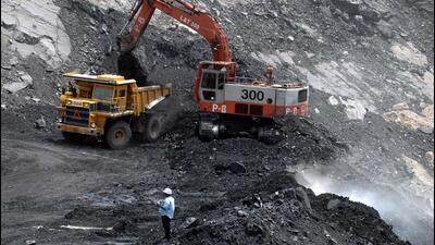 Workers use heavy machinery to shift a pile of coal at an open cast mine in India. (AFP File Photo)
