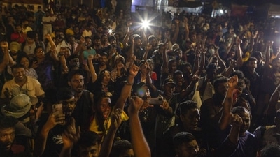 Demonstrators cheer after hearing the news that Gotabaya Rajapaksa, resigned from the President's post at a protest site close to the president's office in Colombo. (Bloomberg)