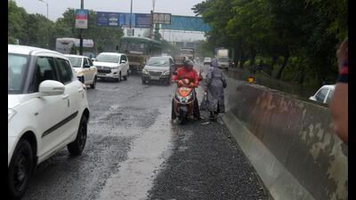 The Ghansoli flyover with potholes. The scooterists had just skidded on the road due to potholes. The Navi Mumbai Municipal Corporation will seek expert opinion from IIT (Bombay) for solution to potholes on four flyovers along Thane-Belapur Road. (BACHCHAN KUMAR/HT PHOTO)