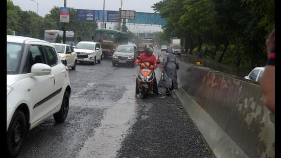 The Ghansoli flyover with potholes. The scooterists had just skidded on the road due to potholes. The Navi Mumbai Municipal Corporation will seek expert opinion from IIT (Bombay) for solution to potholes on four flyovers along Thane-Belapur Road. (BACHCHAN KUMAR/HT PHOTO)