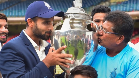 Madhya Pradesh's captain Aditya Shrivastava and head coach Chandrakant Pandit kiss the trophy after winning final Ranji Trophy(PTI)