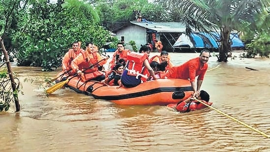National Disaster Response Force (NDRF) personnel conduct a rescue operation to save stranded locals from the flood-hit Chikhli town following heavy monsoon rains, in Gujarat’s Navsari district.(HT_PRINT)