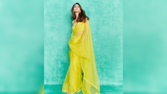 Vaani Kapoor amped up her look by teaming the bright yellow see-through saree with statement earrings and stilettoes.(Instagram/@)_vaanikapoor_)